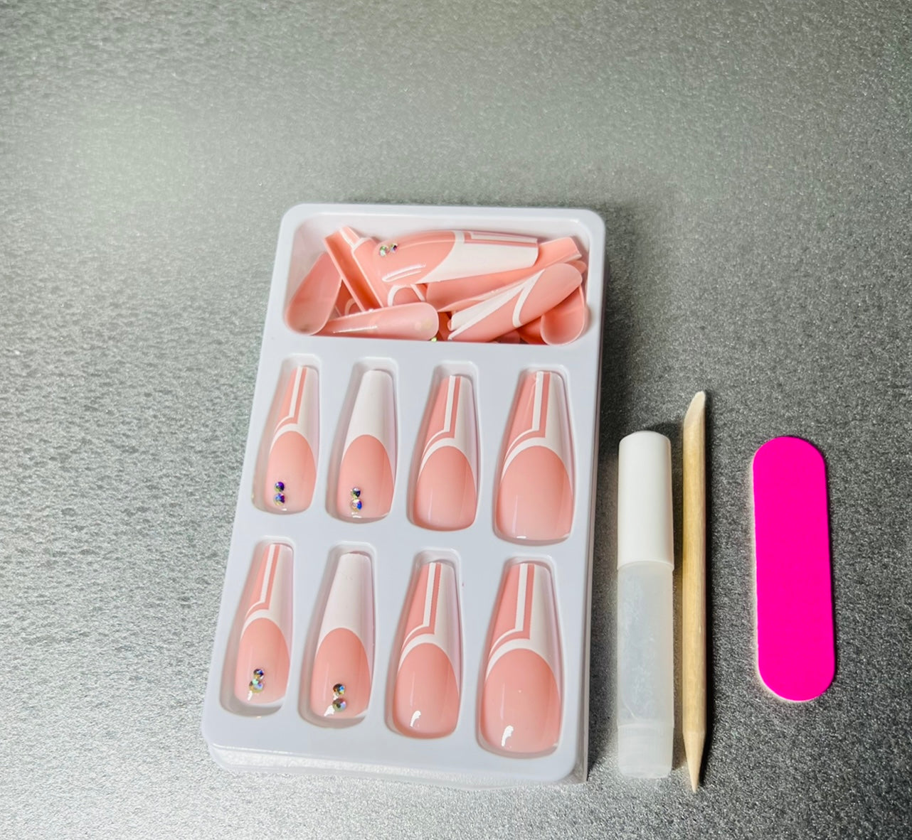 24 press on nails, glue, wooden cuticle pusher, and mini file